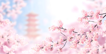 Horizontal banner with sakura flowers of pink color and ancient pagoda on sunny backdrop. Beautiful nature spring background with a branch of blooming sakura. Sakura blossoming season in Japanの写真素材