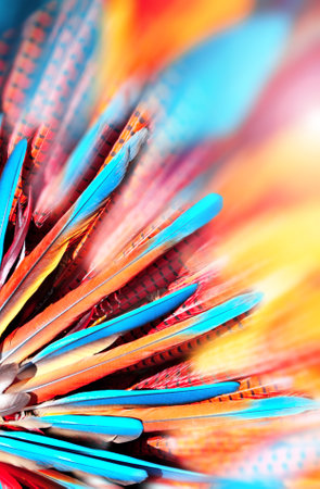 Background with bright multi-colored feathers in native american indian chief headdress. Horizontal or vertical eye-catching banner with colourful blue, orange and red feathers. Copy space for textの写真素材