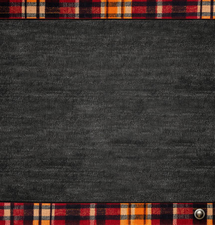 Black denim background with striped borders and decorative button. Dark grey denim jeans fabric texture with plaid edged. Mock up template. Copy space for textの写真素材