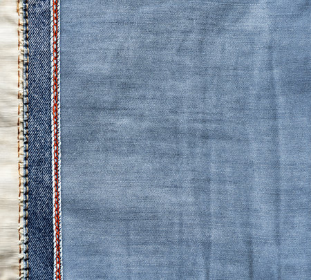 Blue and light grey denim background with a red seam. Light blue color denim jeans fabric texture with decorative border. Copy space for textの写真素材