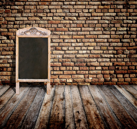 Interior scene with brick wall, wooden floor, advertising billboard in retro style chalkboard in wooden frame. Open space with old wall, wooden floor, cafe menu or pointer board. 3d renderの写真素材