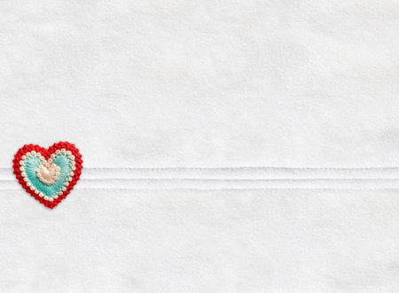 Horizontal Christmas backdrop with suede texture of ivory color and felt heart.  Can be used for scrapbooking winter design. Warm winter time background. Copy space for textの写真素材