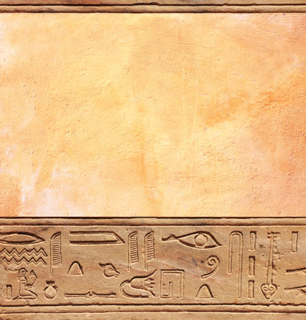 Vertical background with ancient Egyptian hieroglyphs on stone wall, Egypt, Africa. Backdrop with sandstone carving with hieroglyph. Mock up template. Copy space for textの写真素材