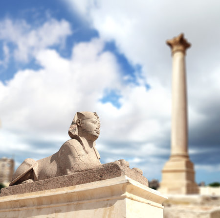 Famous landmark - Serapeum of Alexandria. Sphinx and Pompey's Pillar in Alexandria, Egypt, North Africa. Roman temple Serapeum with Pompey's pillar and sphinxの写真素材