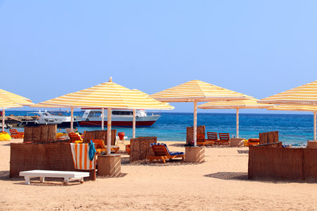 Yachts, loungers and umbrellas near beach and Red Sea, Egypt. Summer vacation, relaxing on tropical beachの写真素材
