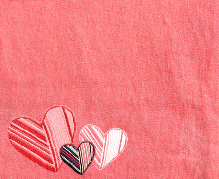 Denim background with felt heart. Horizontal coral color denim jeans fabric texture with heart-shaped textile patch. Valentine's day denim backdrop. Copy space for textの写真素材