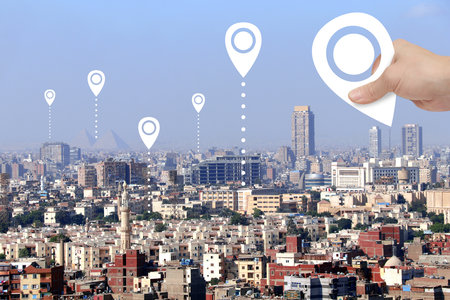 Planning a tourist trip. Top view of Cairo with Great Pyramids and hand with location pin. Travel way,  point navigation concept. Global positioning system pin map. Modern travel, sightsee, tourismの写真素材