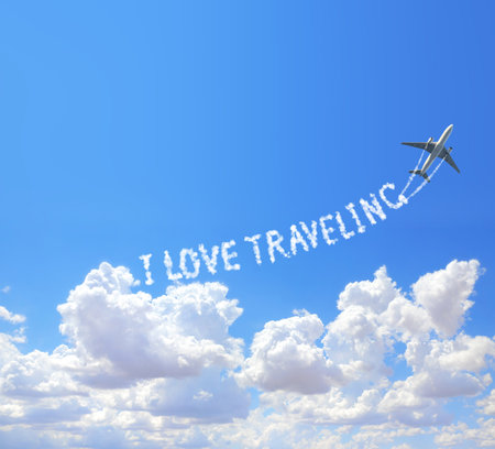 Blue sky with aircraft and Jet trailing smoke. Horizontal banner with airplane drawing a word I love traveling in sky. Topic of summer holiday, travel, trip abroad on vacation, cruises and toursの写真素材