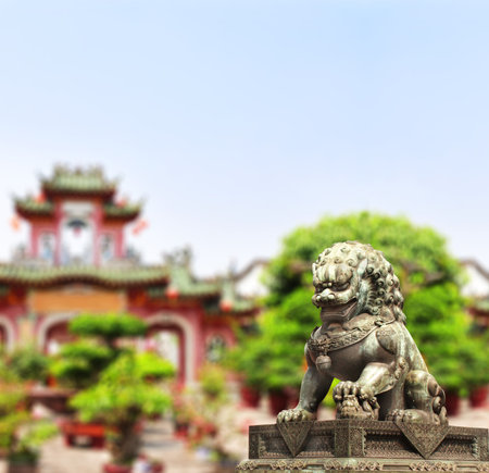 Horizontal background with chinese temple, trees and ancient lion statue. Bronze guardian lion and picturesque landscape, China. Topic of vacation, travel, trip abroad on vacation, cruises, toursの写真素材