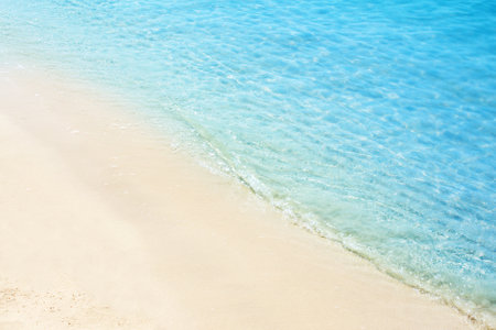 Sea waves on the sand beach. Starfish on the sand of an ocean coast. Tropical resort. Summer time concept. Topic of relaxing on the beach,  vacation, travel, trip abroad on vacation, cruises and toursの写真素材