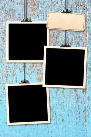 Retro Photo hanging on paper clip against wood wall. Nostalgic Picture album with old photoframes for cherished memories, creating a unique display. Vintage style mood boardの写真素材