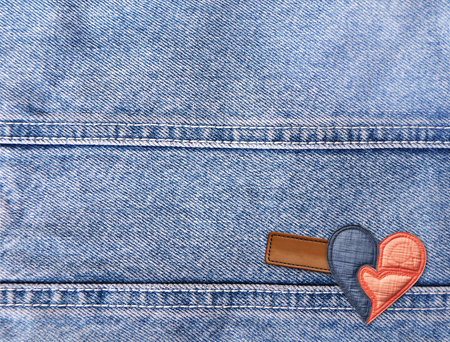 Light blue denim background with felt heart and leather label. Horizontal blue color denim jeans fabric texture with heart-shaped textile patch. Valentine's day denim backdrop. Copy space for textの写真素材