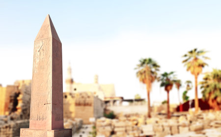 Horizontal banner with ancient egyptian granite obelisk, palm and temple, Luxor (ancient Thebes), Egypt, North Africa. Topic of vacation, travel, trip abroad on vacation, cruises and toursの写真素材