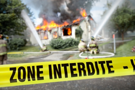 French  Zone Interdite  tape with firefighters and a burning house in the backgroundのeditorial素材