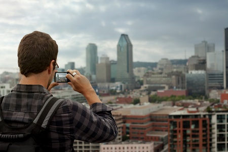 Man Taking a Picture from a High Point of View of Downtown Montreal during beautiful a cloudy day.の写真素材