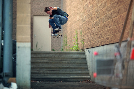 Young Skateboarder doing a Kickflip down the stairsの写真素材