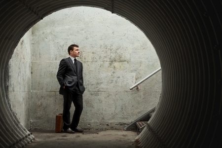 Patience is a virtueâ¦ Businessman waiting for something or someone in a tunnelの写真素材