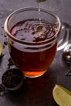 Squeezeing a lemon juice into a teaの写真素材