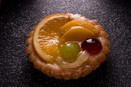 Delicious mini tarts with pudding filling and some fruitsの写真素材