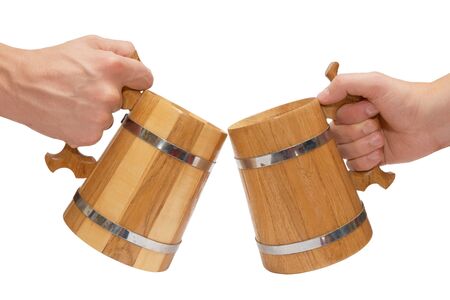 Two men's clinking of big wooden beer mugsの写真素材