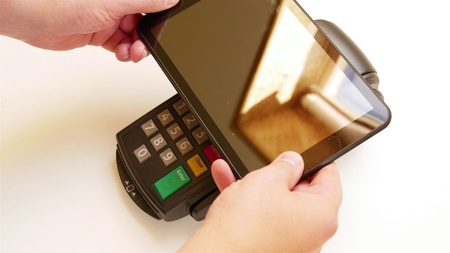 Paying with a tablet device wirelessly over credit card terminal.の写真素材