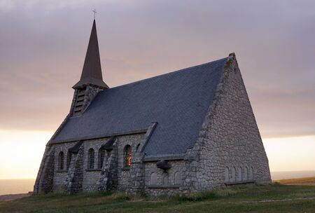 Temple church made of stone by the evening sea, the light is on in the window. Rouen city, France 07.20.2019のeditorial素材