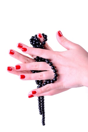 Young woman holding black beads, red nailsの写真素材