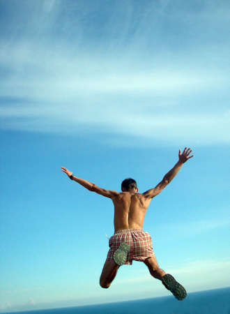 The jumping person on a background of the skyの写真素材