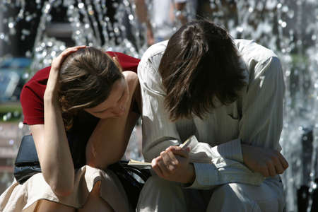 The young man and the girl read the book in the streetの写真素材