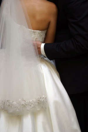 The groom embraces the brideの写真素材