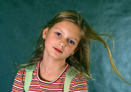 Portrait of the girl with fluttering hair on a dark blue backgroundの写真素材