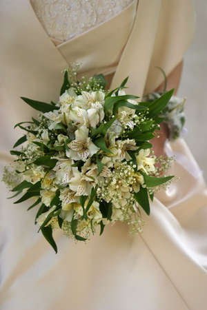 Wedding bouquet on a background of a satiny wedding dressの写真素材