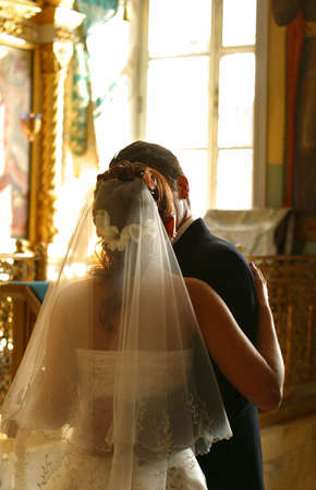 Newly-married couple in church after wedding congratulate each otherの写真素材
