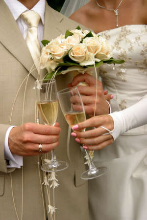 Glass of champagne in a hand of the groom and brideの写真素材