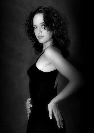 Portrait of the harmonous girl in a black dress on a dark background. b/wの写真素材