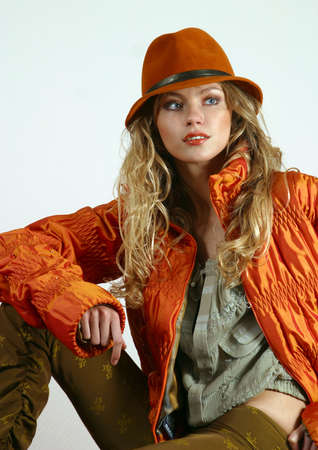 The beautiful young blonde in a red jacket and a hatの写真素材