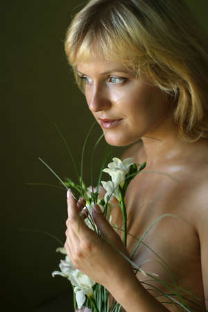 Portrait of the beautiful blonde with a bouquet of flowersの写真素材