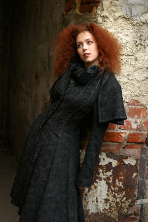 Portrait of the girl with red hair in a black coatの写真素材