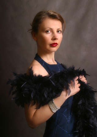 Portrait of the beautiful woman in an evening dress with feathers