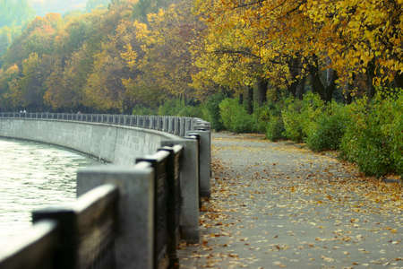 Autumn park along quay of the riverの写真素材