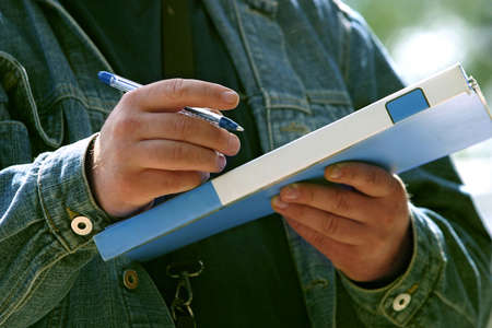 The man holds a dark blue folder and the handleの写真素材