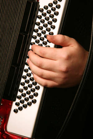 Hand of the musician with the instrument on a black backgroundの写真素材