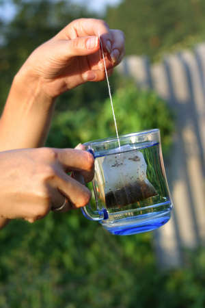 Female hand with a cup of water on a dim backgroundの写真素材