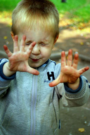 The little boy shows dirty palmsの写真素材