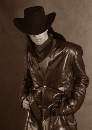 Portrait of a young man in hat in studio. b/w+sepiaの写真素材