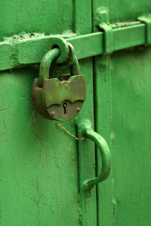 The image of the old lock on a green doorの写真素材