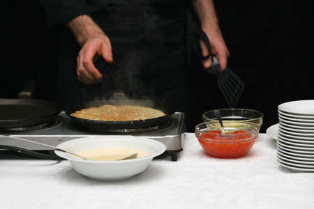 The cook fries pancakes with caviarの写真素材