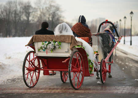 The groom and the bride in a vehicle with red wheelsの写真素材