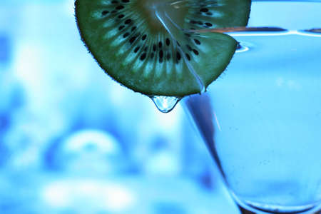 Glass with a plate kiwi on a dark blue backgroundの写真素材