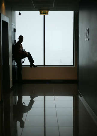 The man with reflection stands at a windowの写真素材